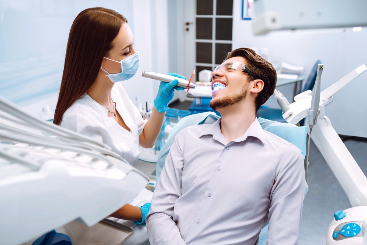 young-man-at-the-dentist-s-chair-during-a-dental-procedure-overview-of-dental-caries-prevention-.jpg